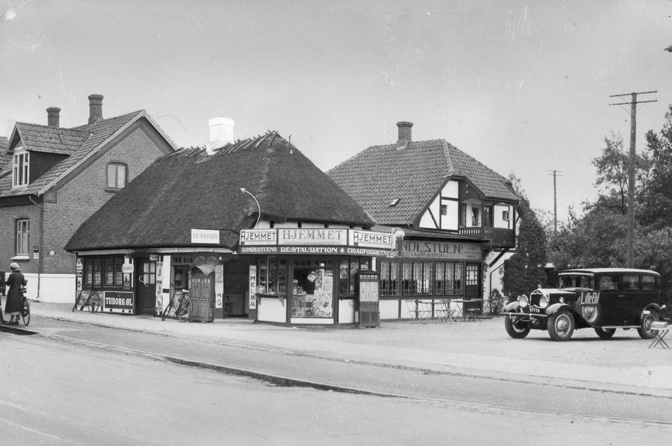 Bondestuen med tidens biler foran, historisk fotografi
